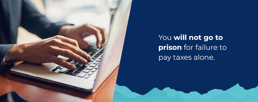 person typing and assurance a person will not go to jail for not paying taxes